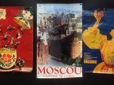 three posters of different countries are displayed on a black surface