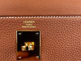 a close up of a brown purse with a ring on it