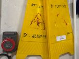 un panneau d'avertissement jaune accroché au mur à côté d'un poteau vert