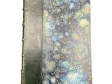 a close up of a book on a white surface with a blue and yellow cover