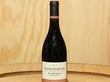 une bouteille de vin posée sur un tonneau