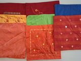 Quatre saris de couleurs différentes sont alignés sur une table