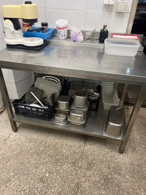 a stainless steel table with pots and pans on it