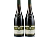two bottles of wine sitting next to each other on a white surface