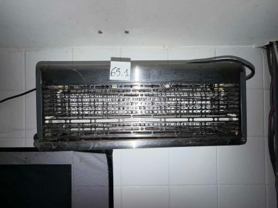 un vieux climatiseur posé sur un mur carrelé