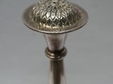 a silver candle holder with a flower design on top of it