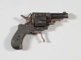 un petit pistolet posé sur une surface blanche