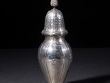 an image of a silver vase with a lid on a table