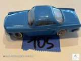 une petite voiture bleue posée sur une feuille de papier