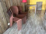 four plastic chairs in a room with a table and a lamp