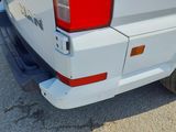 a close up of a white truck with a red tail light