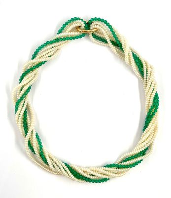 un gros plan d'un collier blanc et vert posé sur une surface blanche
