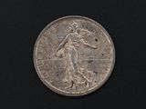 a close up of a silver coin on a black surface