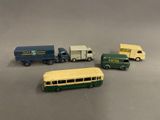 quatre camions miniatures et un bus posés sur une table