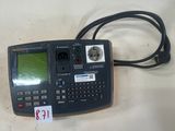 une calculatrice reliée à un cordon, posée sur une table