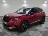 un SUV rouge garé sur un sol à damier dans un garage