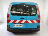 a blue van with red and white stripes parked in a white room