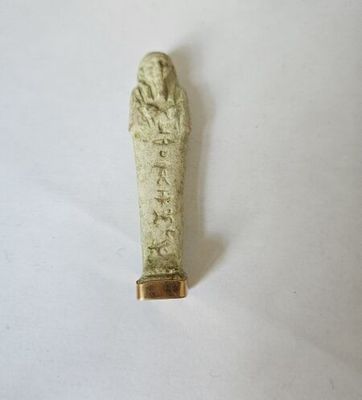 une image représentant une petite statue d'une personne avec une main posée sur la tête