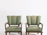 une paire de fauteuils rembourrés verts avec accoudoirs