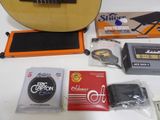 a guitar, a guitar case, a guitar tuner, and other musical equipment