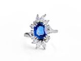 a close up of a blue sapphire and diamond ring on a white background