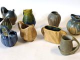 de nombreux vases de styles variés posés sur une surface blanche