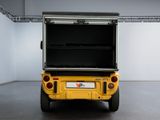 the back end of a yellow golf cart in a room