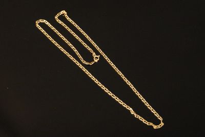 a gold necklace with a long chain on a black background
