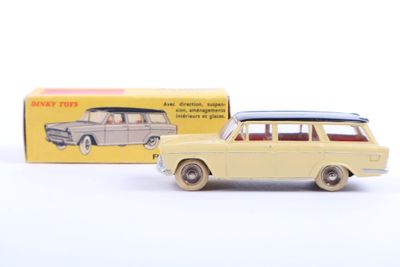 yellow toy car with surfboard on top in front of a box