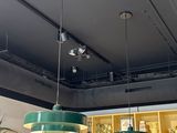 trois lampes vertes suspendues au plafond d'un magasin