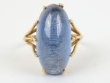 a close up of a ring with a blue stone in it
