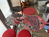 four stools that have been painted with a picture of grapes on them