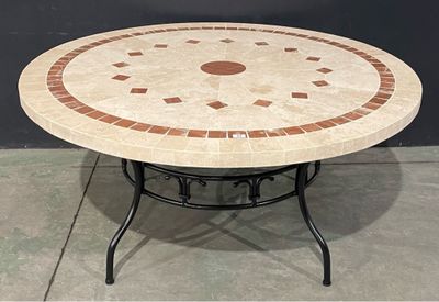 une table ronde avec un plateau en carrelage posée sur un sol en béton