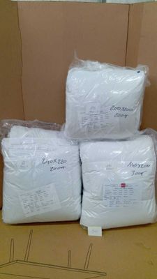 three bags of white pillows sitting on top of a cardboard box