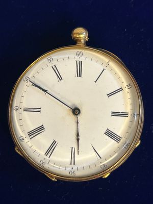 une horloge en or avec des chiffres romains sur le cadran