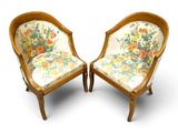 pair of antique chairs with floral upholstered cushions and wooden legs