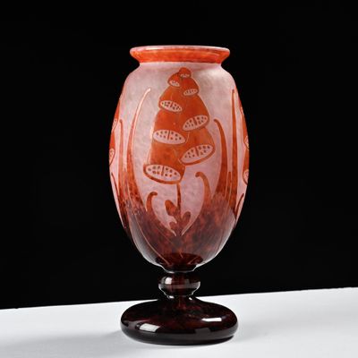 a red vase with a design on it on a table