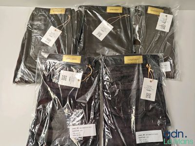 quatre sacs de vêtements posés sur une table, avec leurs étiquettes