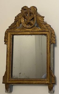 a mirror hanging on the wall with a gold frame