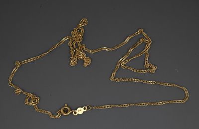 a close up of a gold necklace with a cross on it
