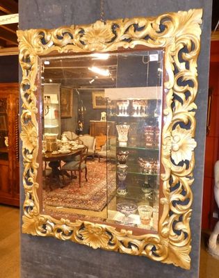 un miroir à cadre doré au milieu d'une pièce