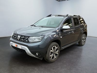 La Dacia grise est garée dans un showroom où il y a une horloge accrochée au mur.