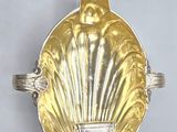 an image of a gold shell shaped ring with a diamond in the center