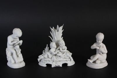 trois figurines blanches représentant des enfants assis sur une surface noire