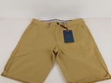 the children ' s shorts are tan with a blue tag on it