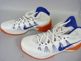 pair of white and blue tennis shoes with orange soles on a white surface