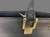 a close up of a black purse with a gold handle