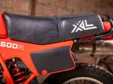 a close up of a red motorcycle parked in a garage