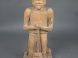 statue d'un homme coiffé d'un chapeau, les bras croisés