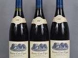 three bottles of wine are lined up on a table